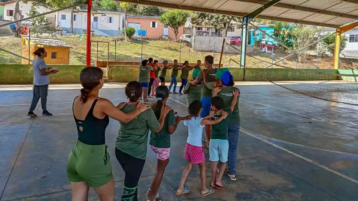 Na quadra de Gesteira, dezenas de participantes, principalmente crianças fazem um "trenzinho" com as mãos nos ombros da pessoa da frente e assim por diante