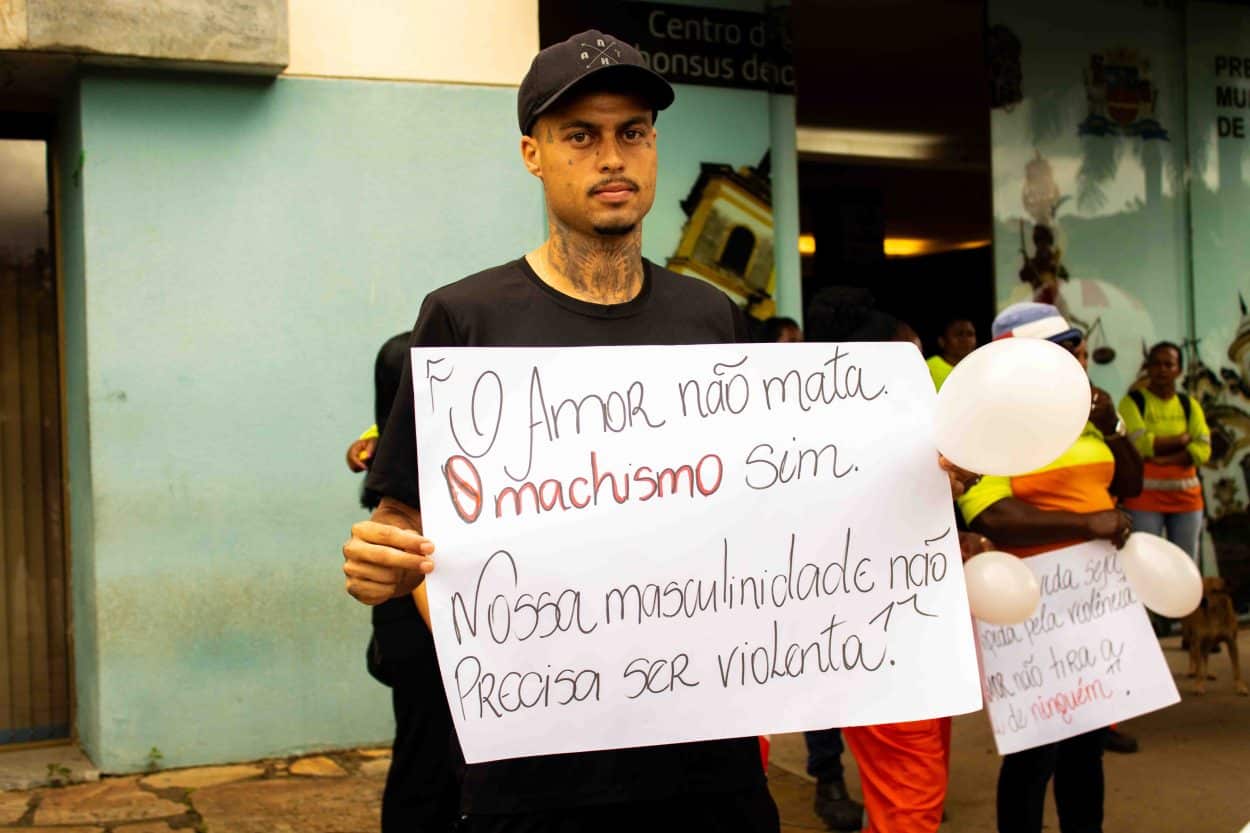 Manifestante carrega cartas em protesto à violência contra mulher.